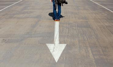 a person standing on a street with an arrow in it