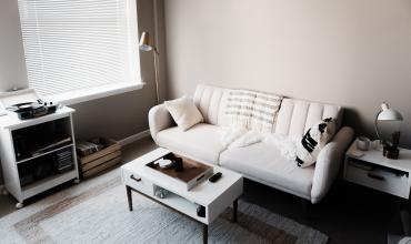 A white sofa and coffee table on a light blue rug