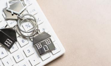 Key chain with houses on it over a calculator