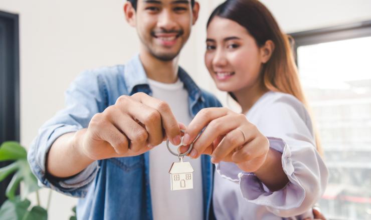 Couple holding up a key to their new home