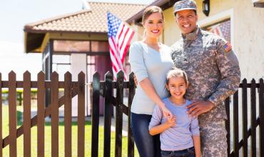 How to Buy a Home as a Military Veteran A military family standing in front of their home