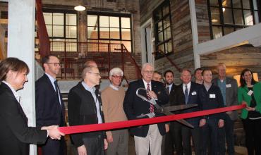 people lining up to cut the ribbon