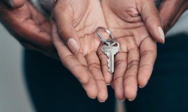 Two hands holding house keys