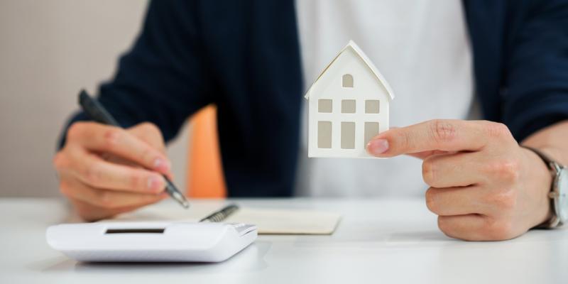 A hand holding a paper house