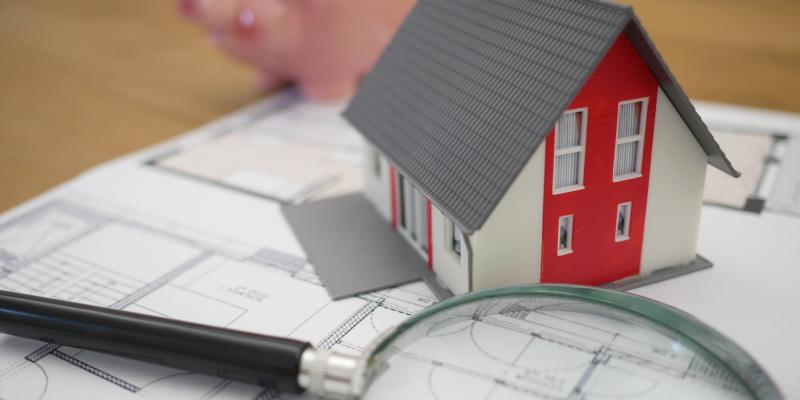 a magnifying glass and a piggy bank sitting on a table with papers