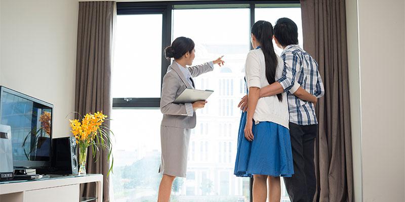 Realtor with couple looking out window