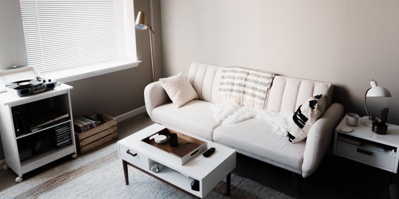 A white sofa and coffee table on a light blue rug