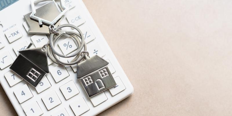 Key chain with houses on it over a calculator