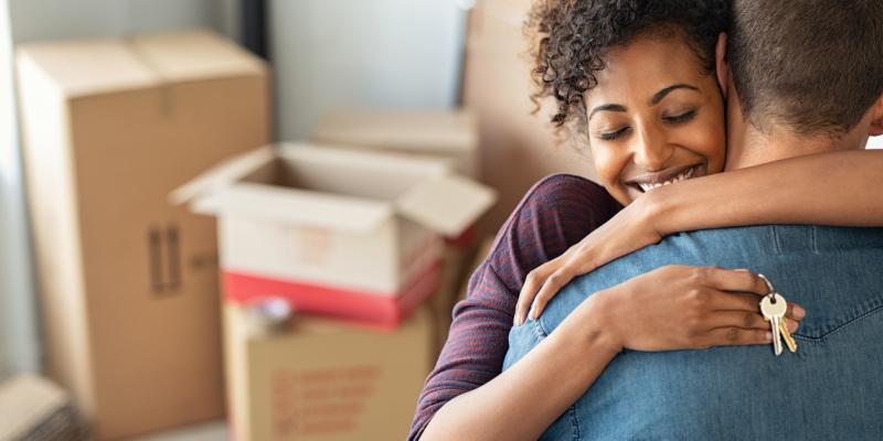 A couple hugging and holding a key to their new home