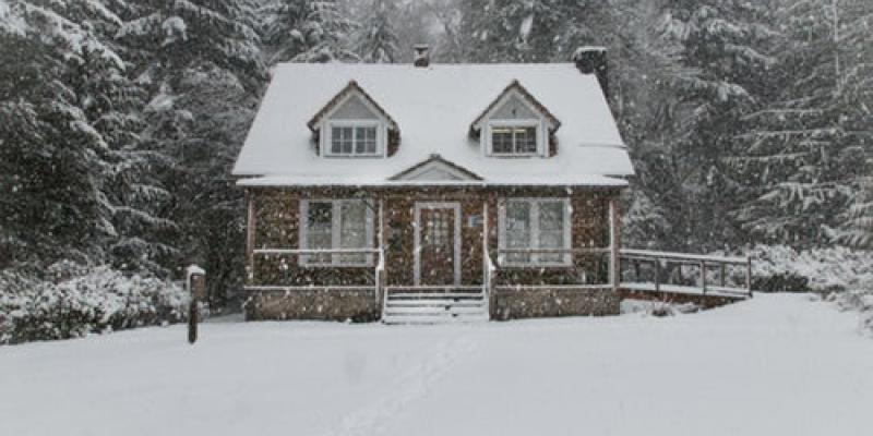 A small house surrounded by snow