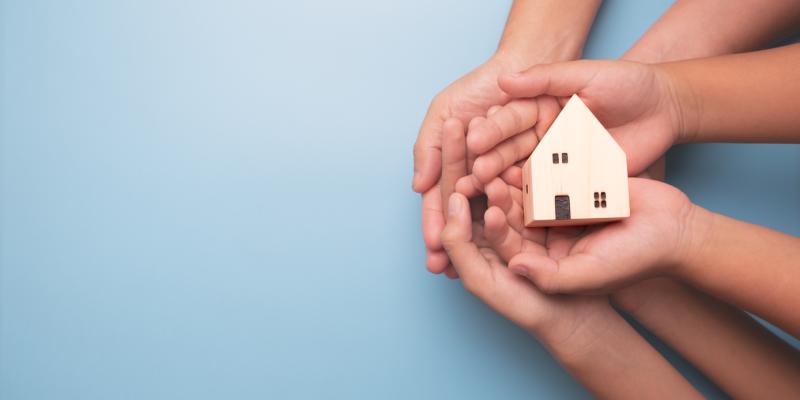 Is Your Home Ready for an Emergency? Hands holding a little house against a blue background