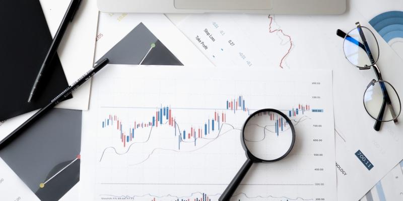 A magnifying glass sitting on a paper with graphs