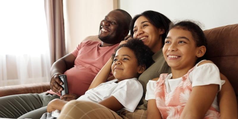 A family sitting on the couch together